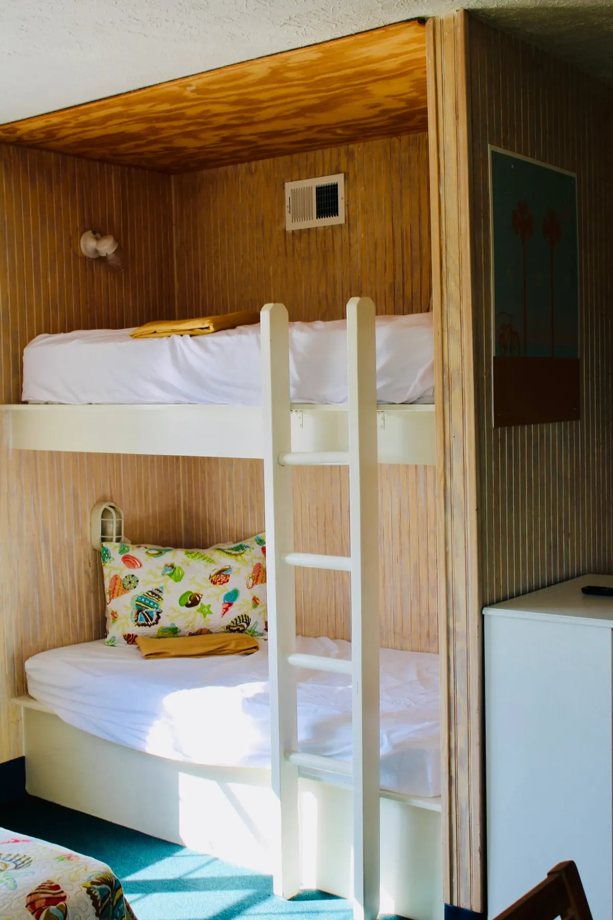 A playful corner featuring bunk beds adorned with colorful pillows and crisp white cabinetry. This setup offers a cozy nook for kids or extra guests, bringing out the studio's flexible sleeping options and practical design for families or groups.